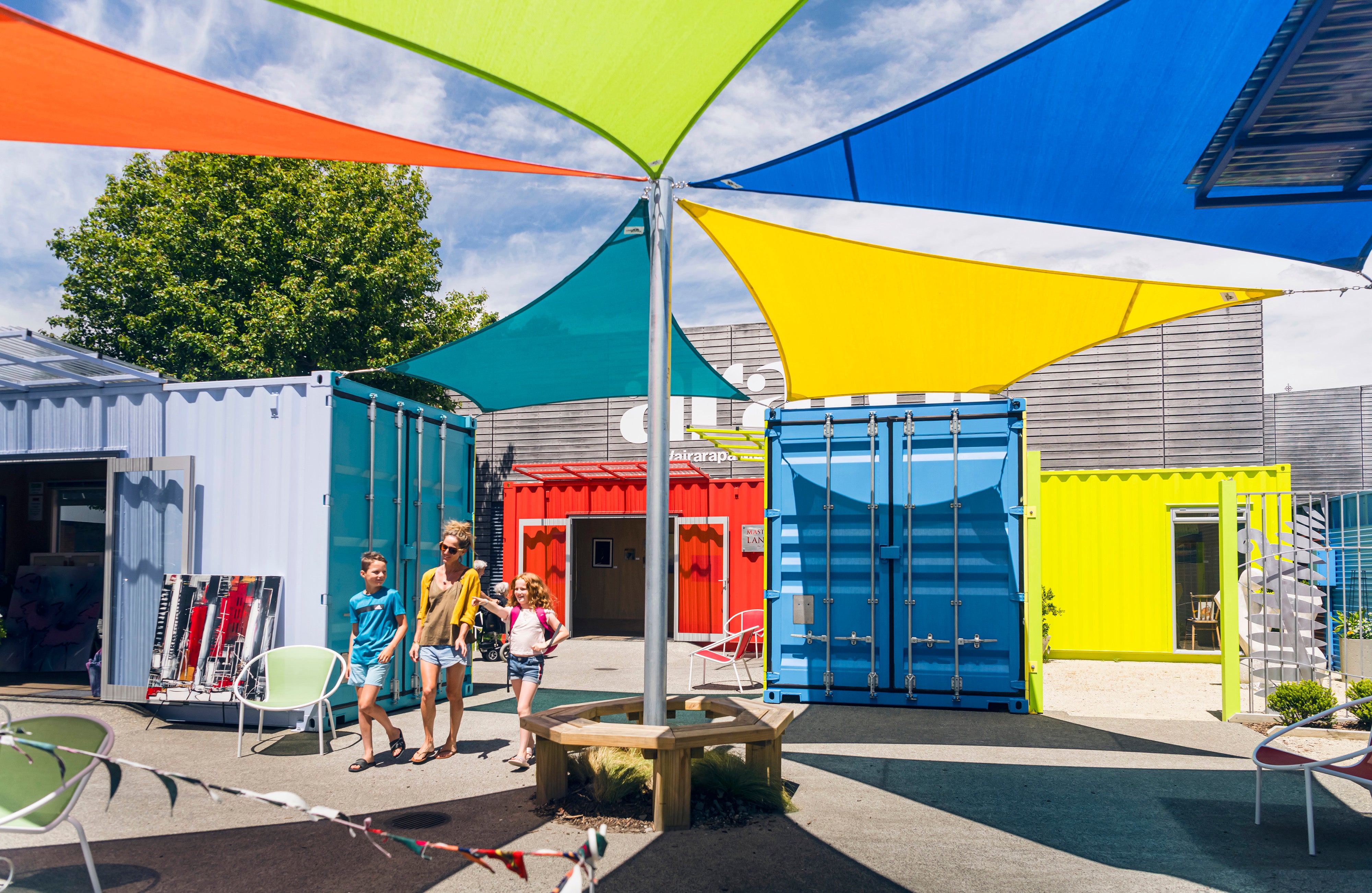 Family walking through colourful containers 