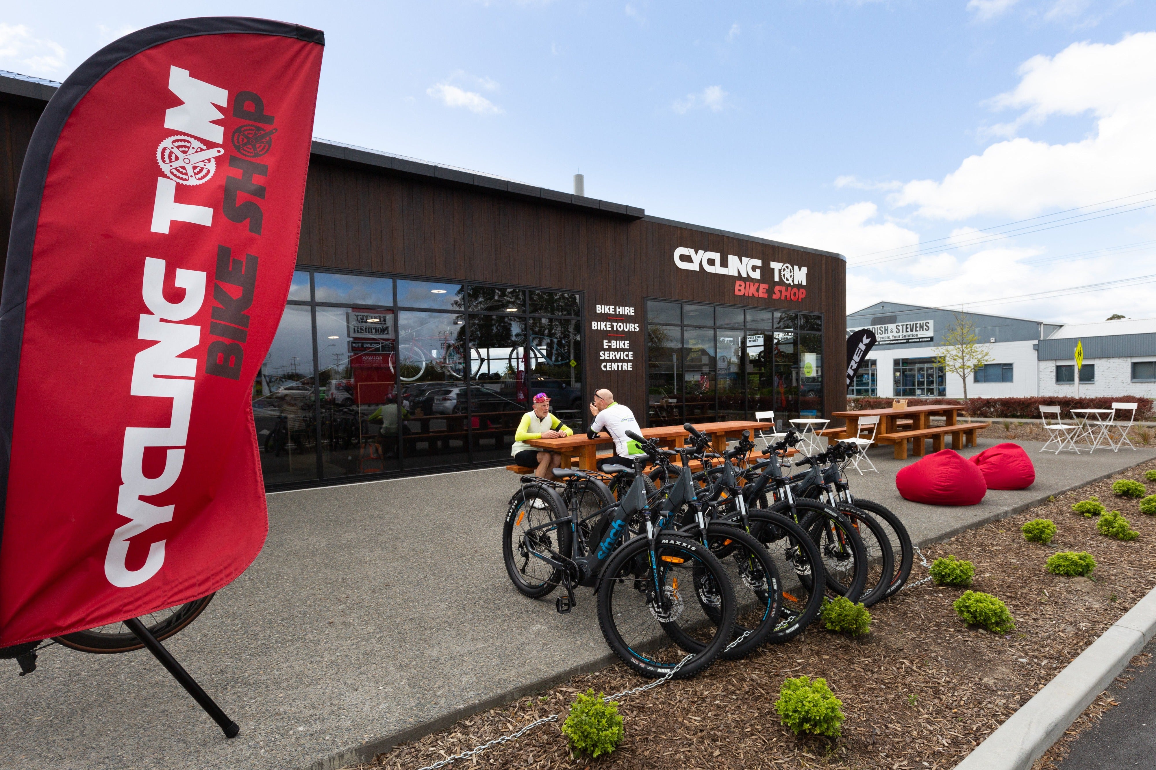 Cyclists sitting outside bike shop