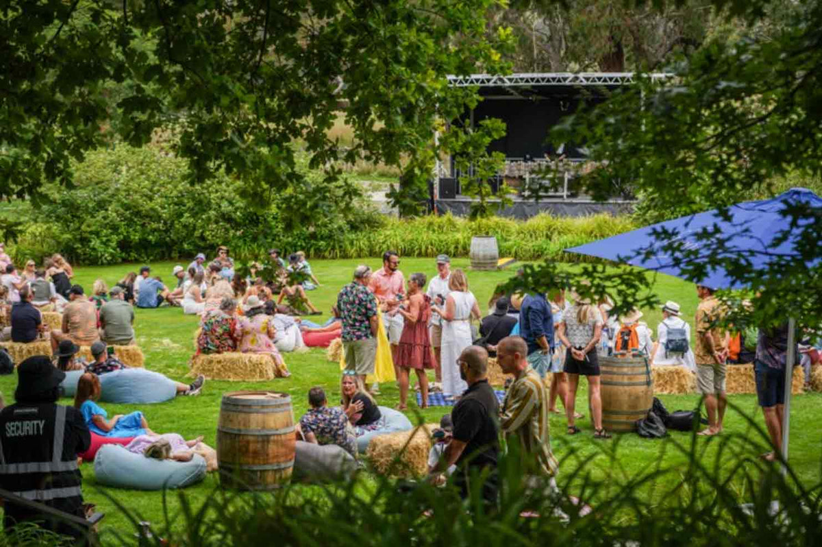 People gathered in groups on hay bales on the lawn