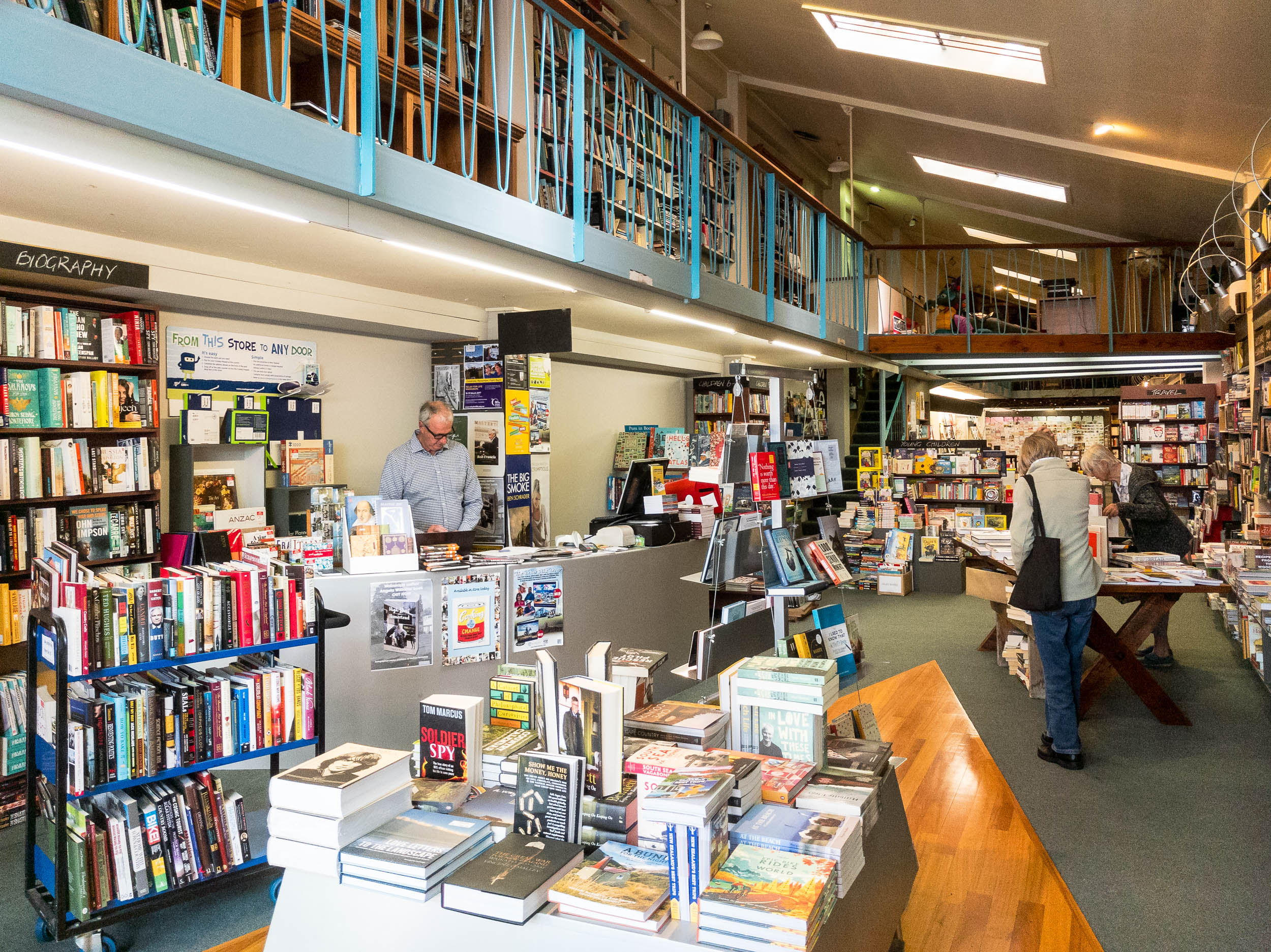 Owner working inside bookstore with customers 