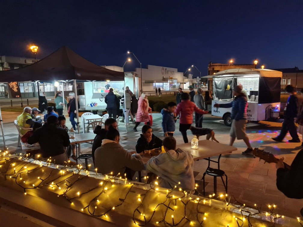 People eating at night outside food trucks 