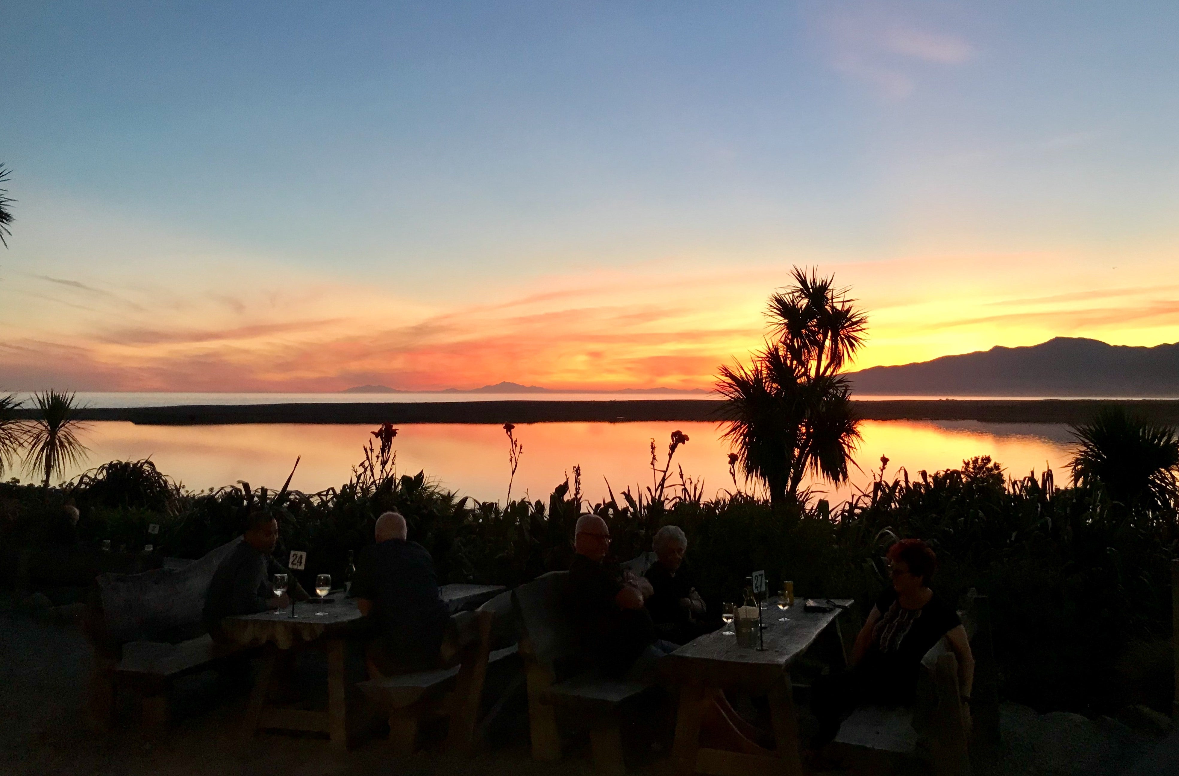 People at tables enjoying sunset 