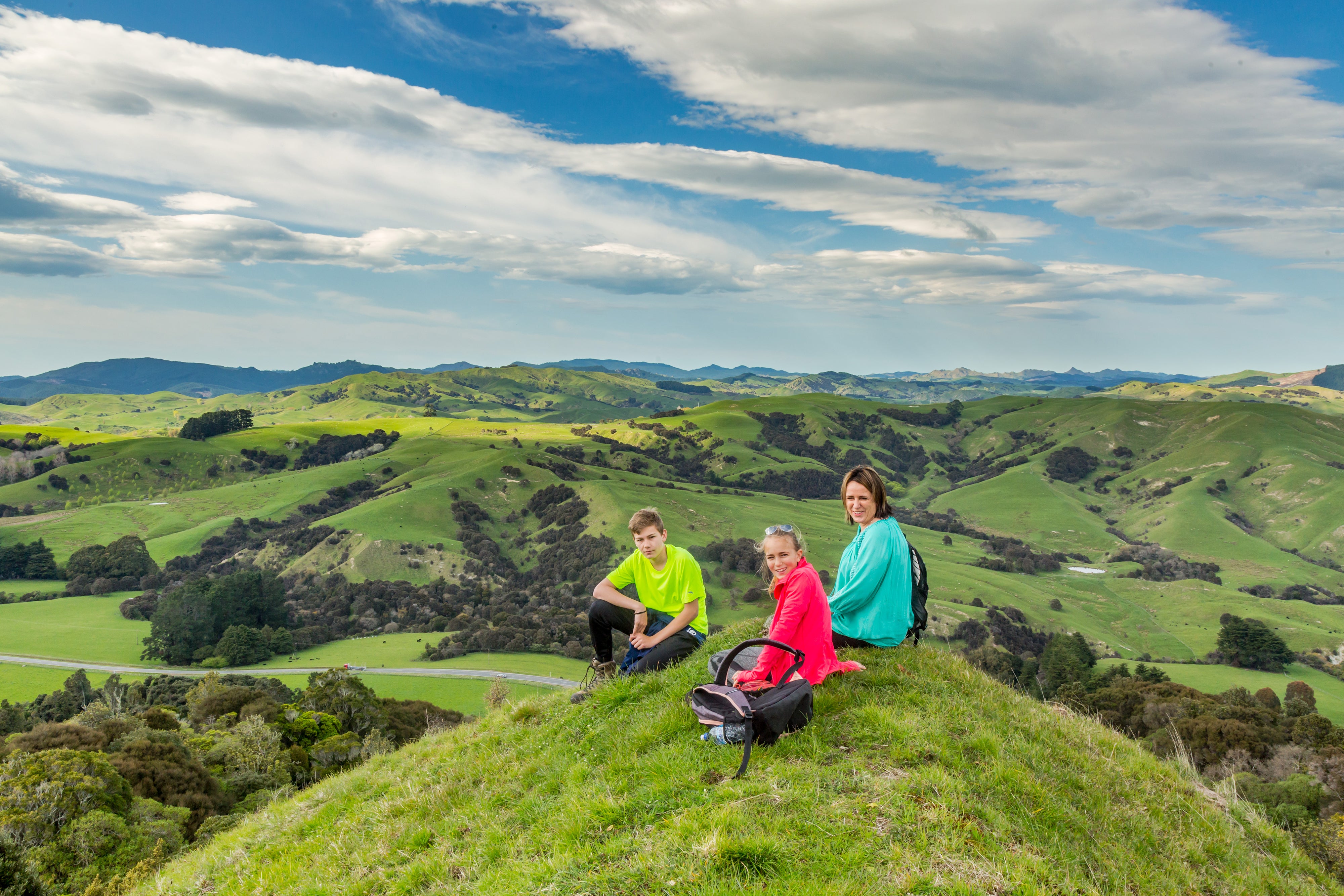 Family sitting on top of hill 