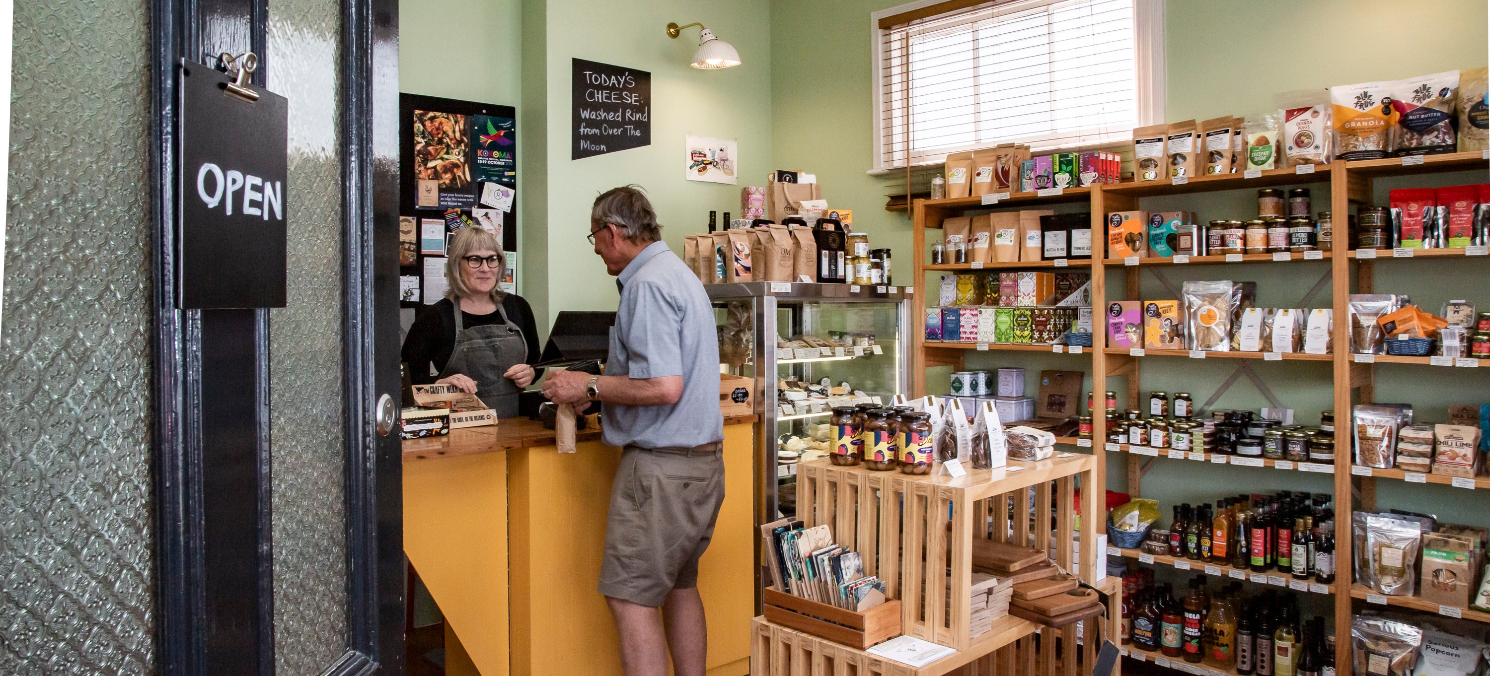 Lady serving man in shop 