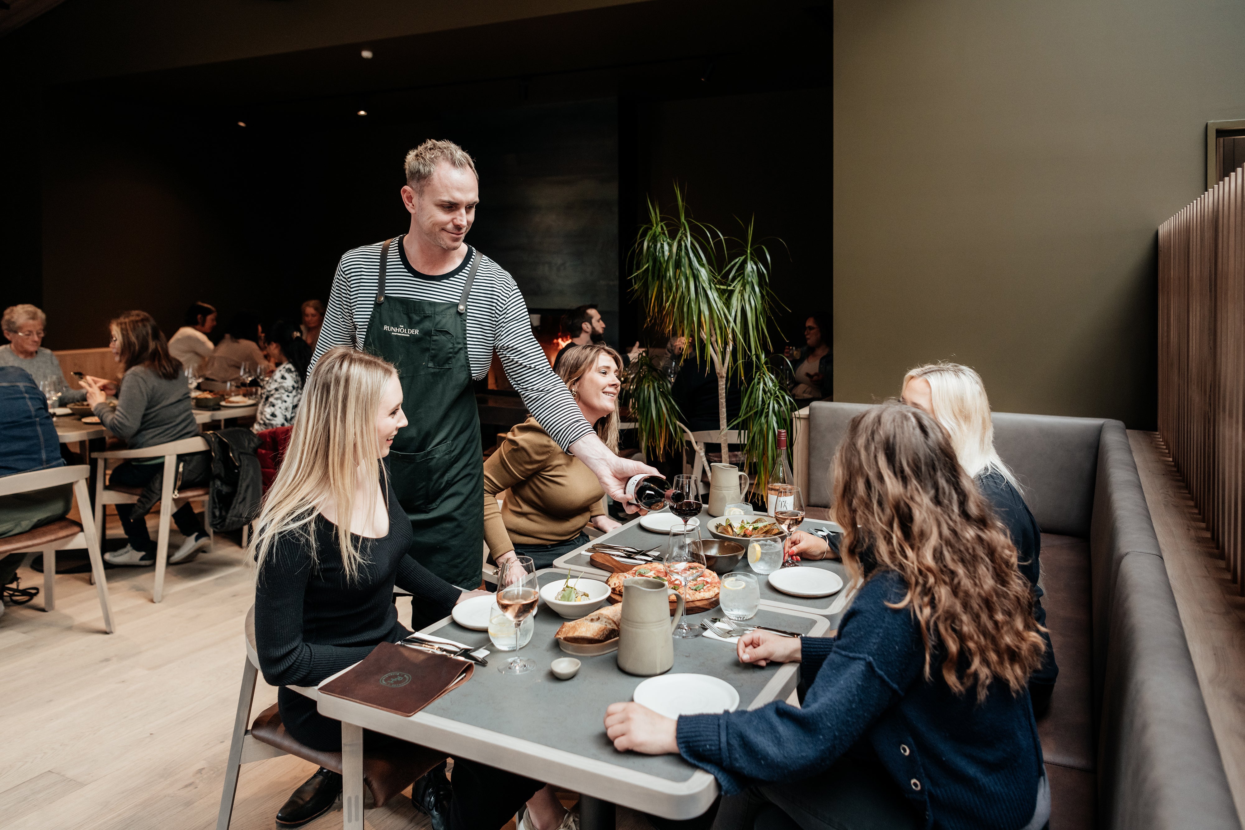 Waiter pouring wine at table 