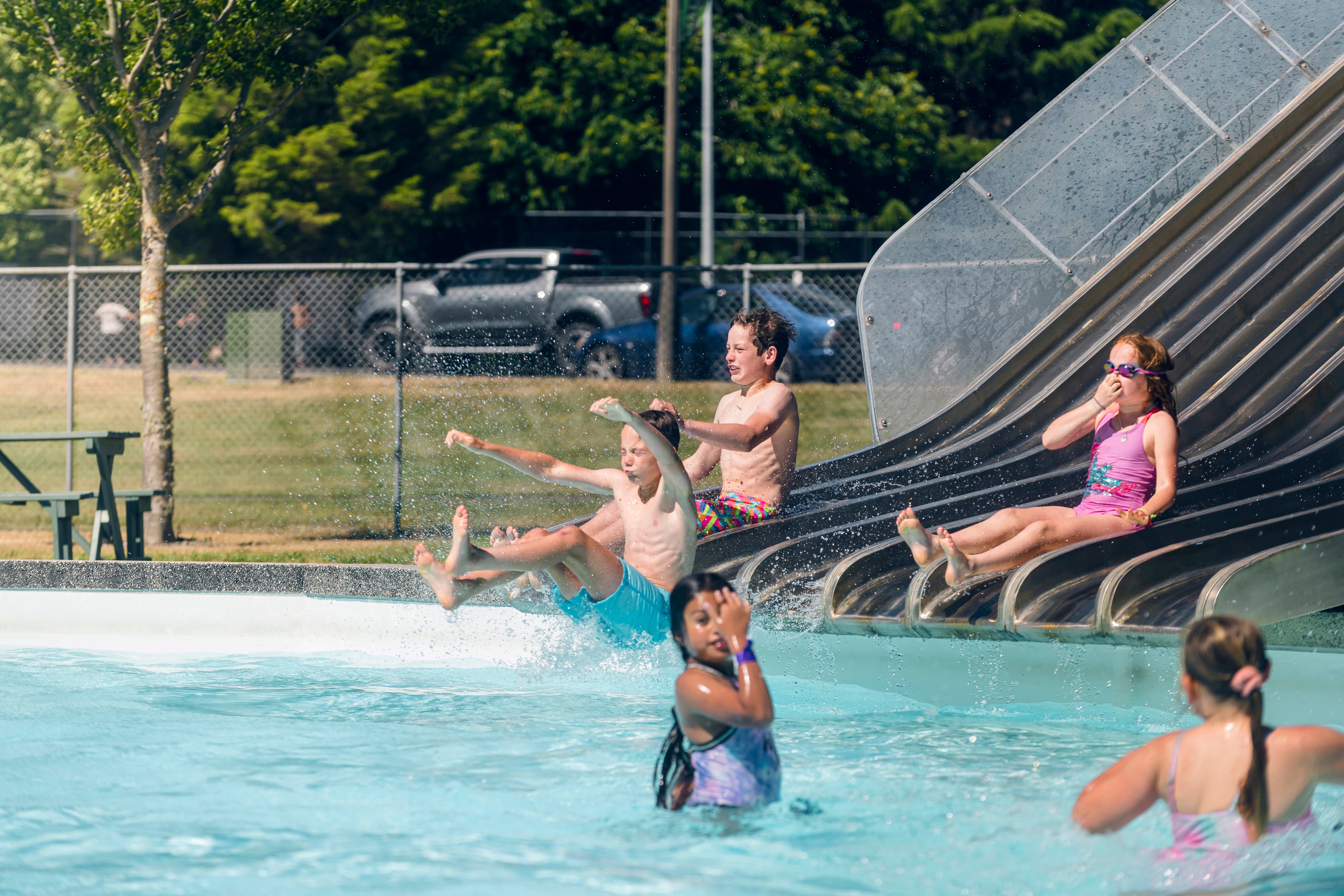 Kids sliding into pool 