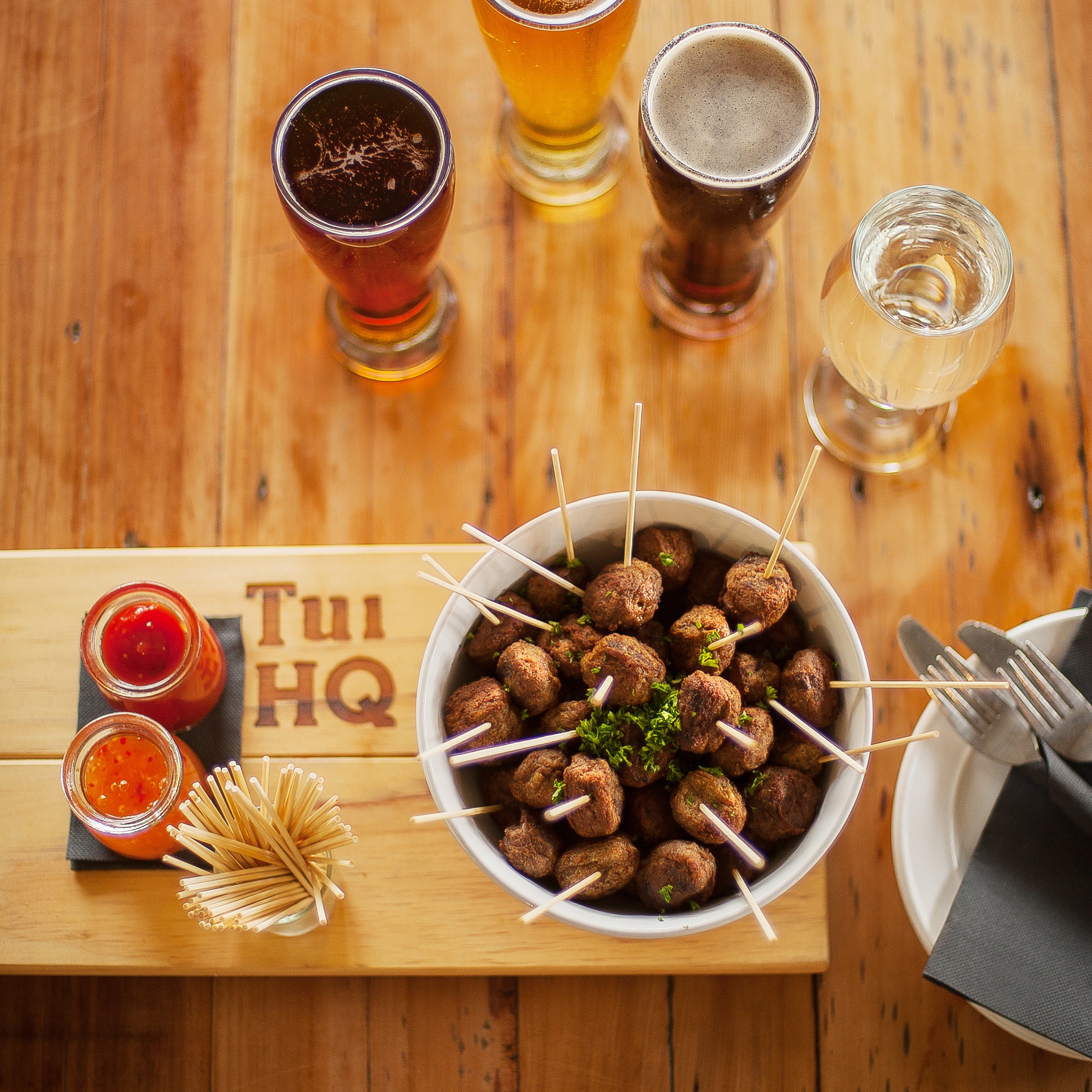 A bowl of snacks and beer on the table 