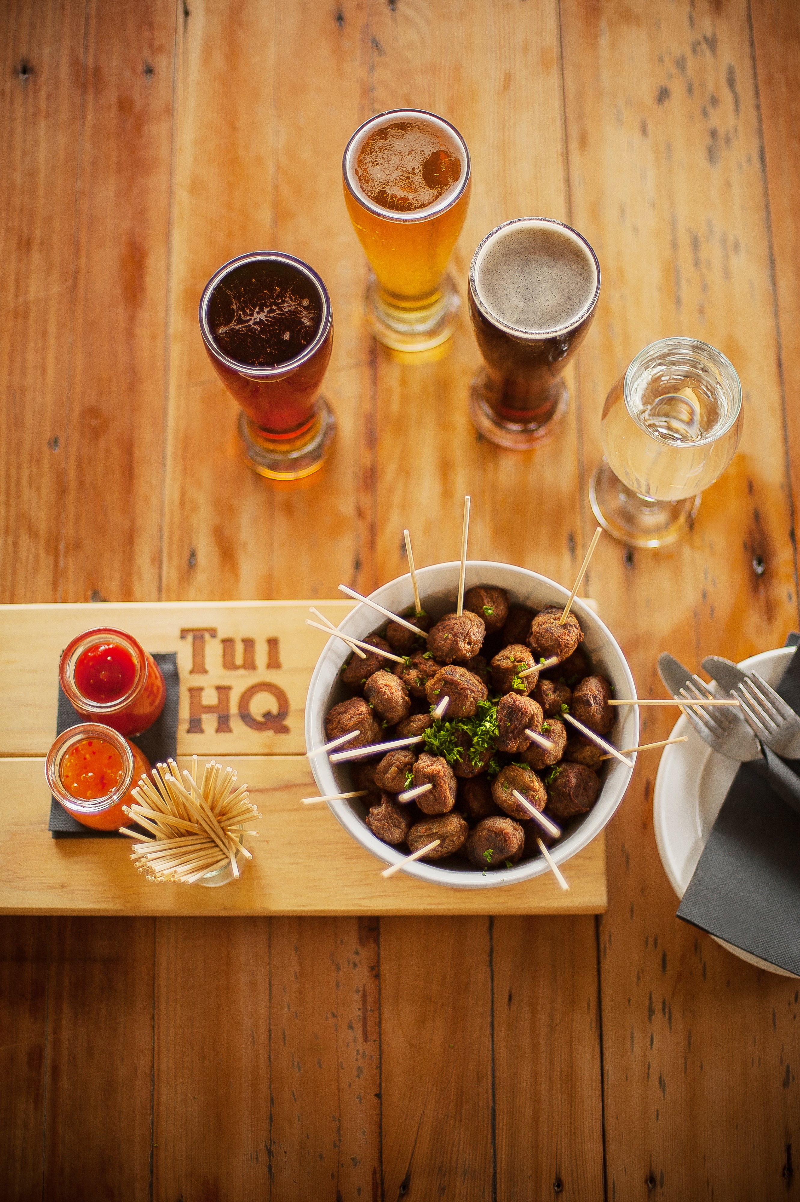 A bowl of snacks and beer on the table 