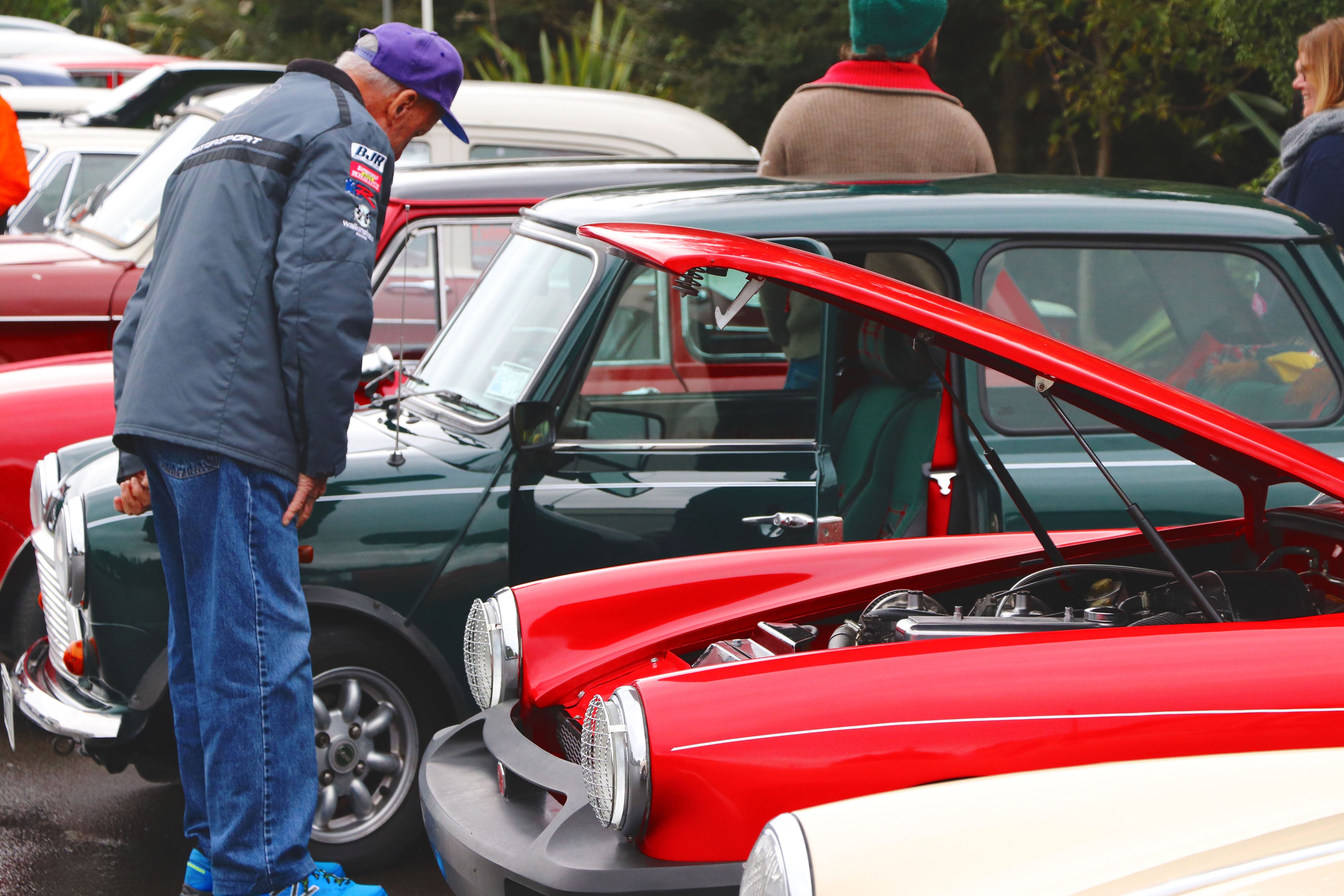 Man looking at engine of classic car 