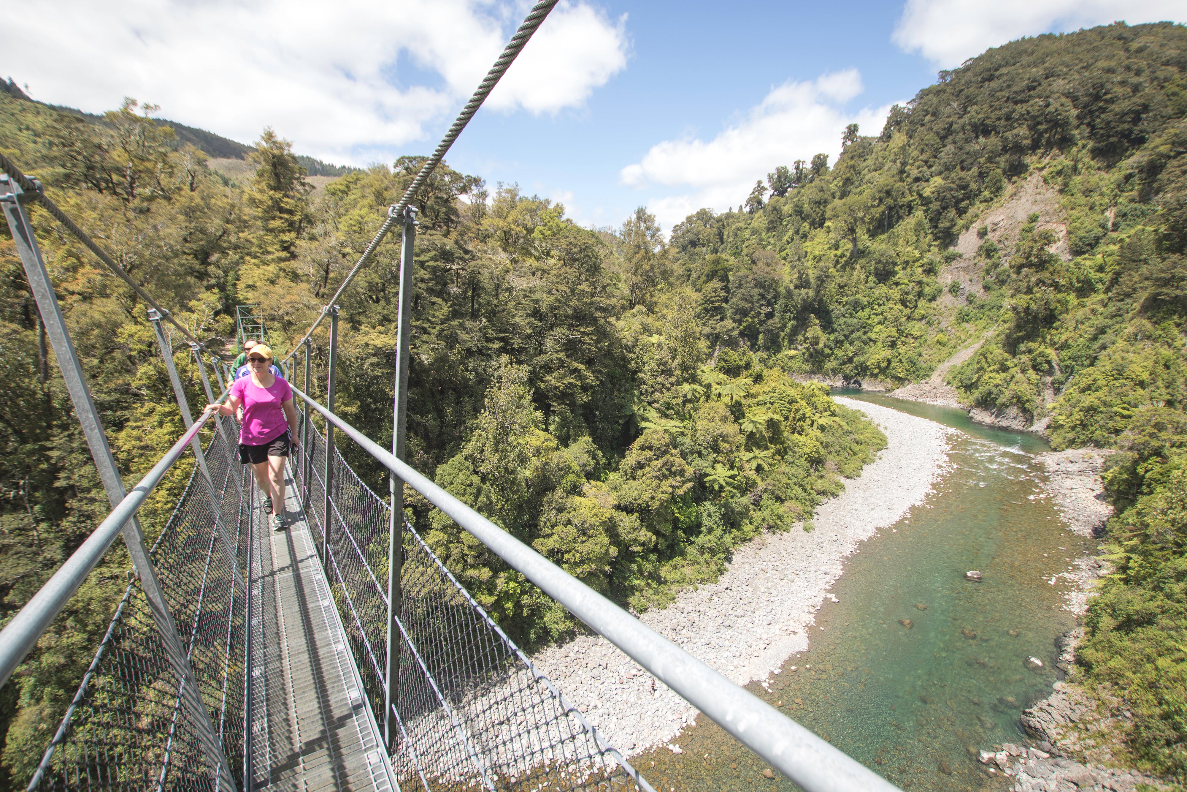 People crossing swing bridge 