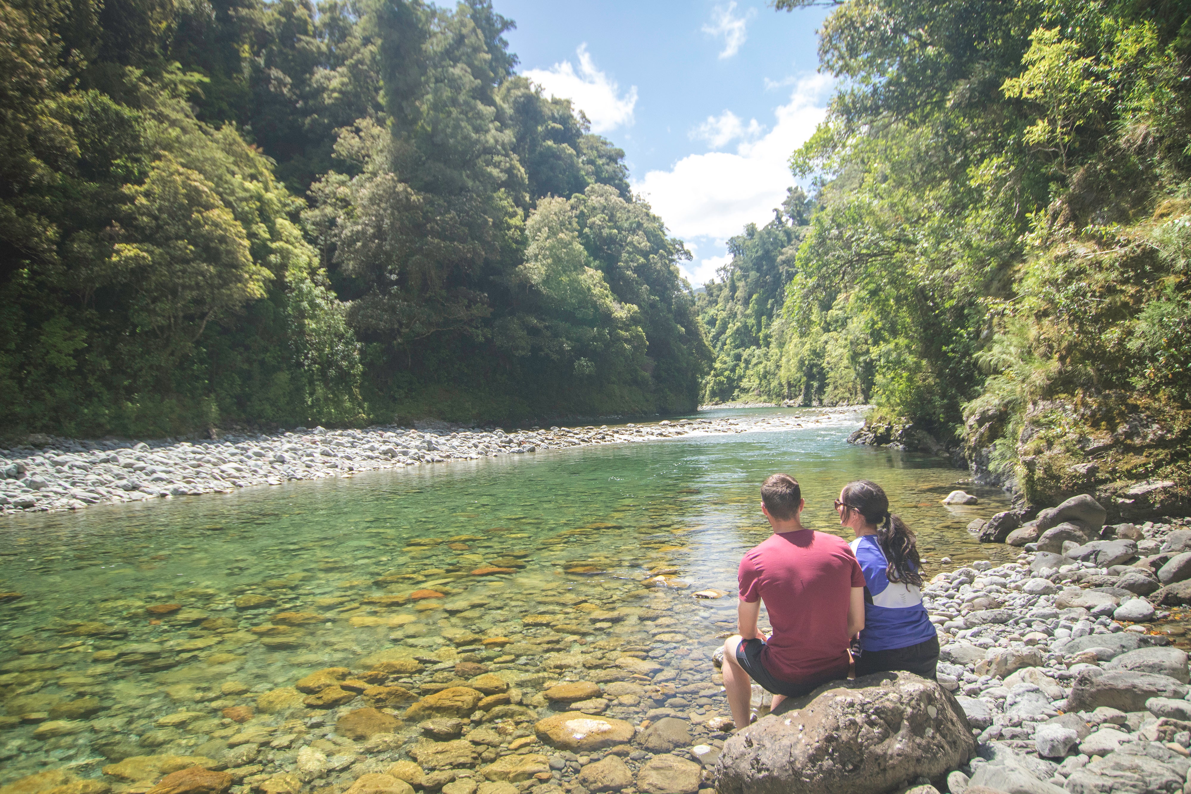 People sitting beside river 