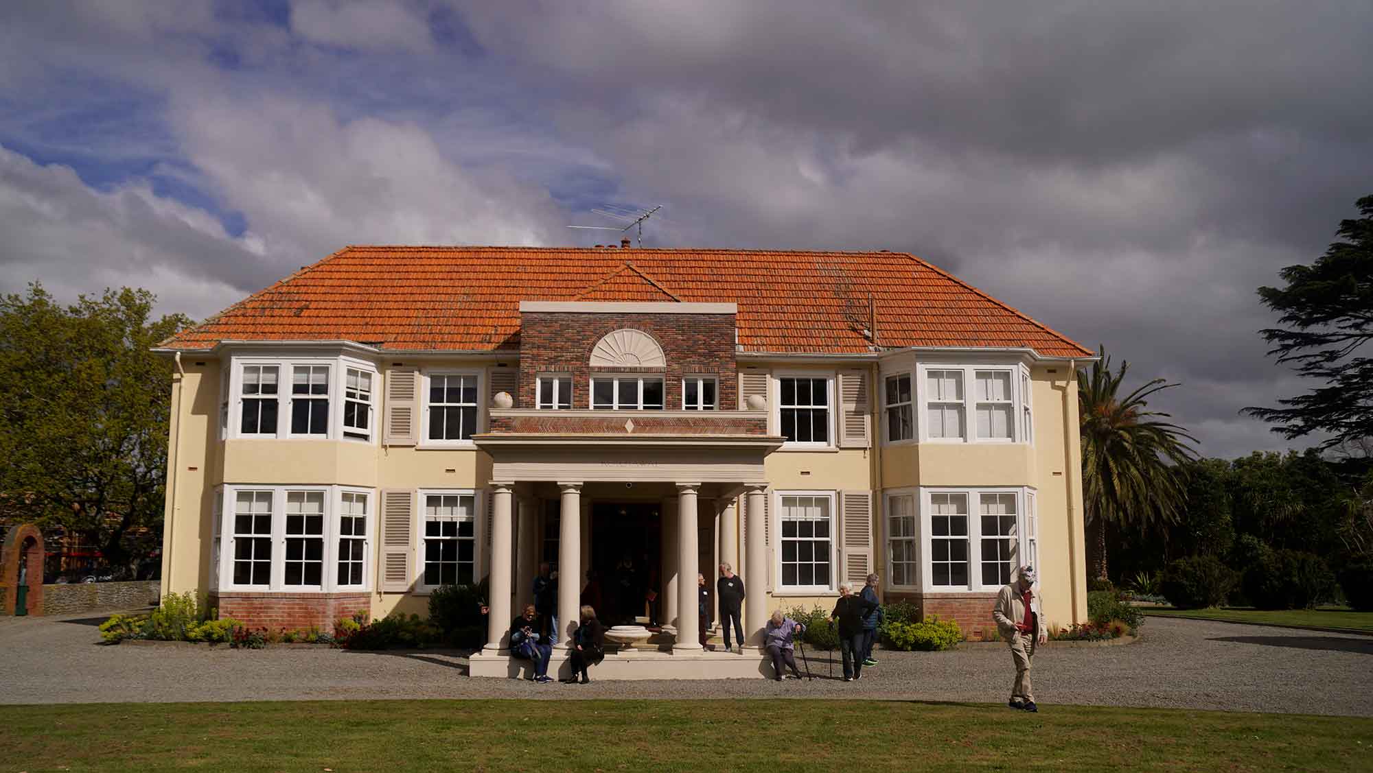 Old homestead with people out the front