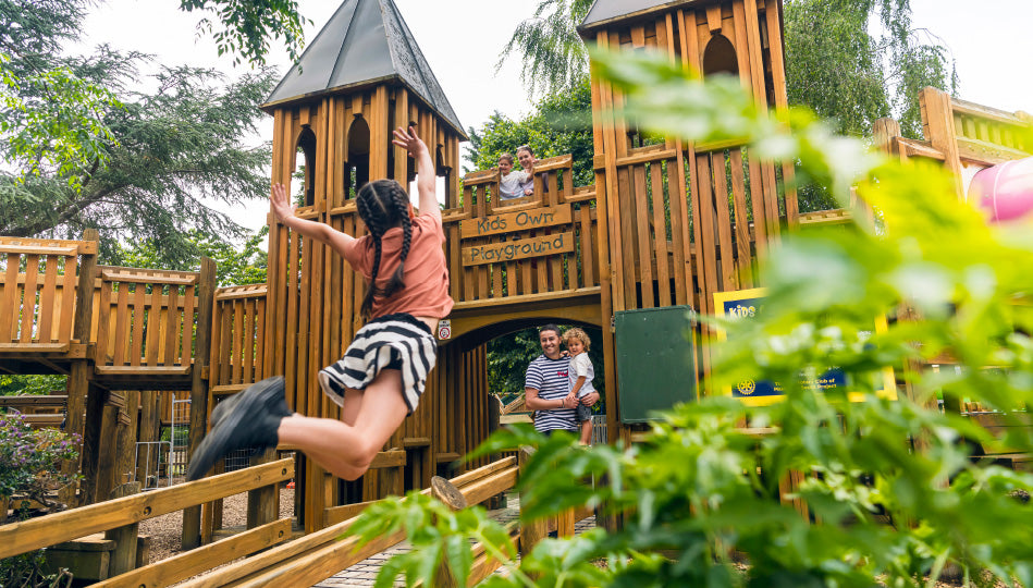 Family at Masterton Queen Elizabeth Park with little girl jumping